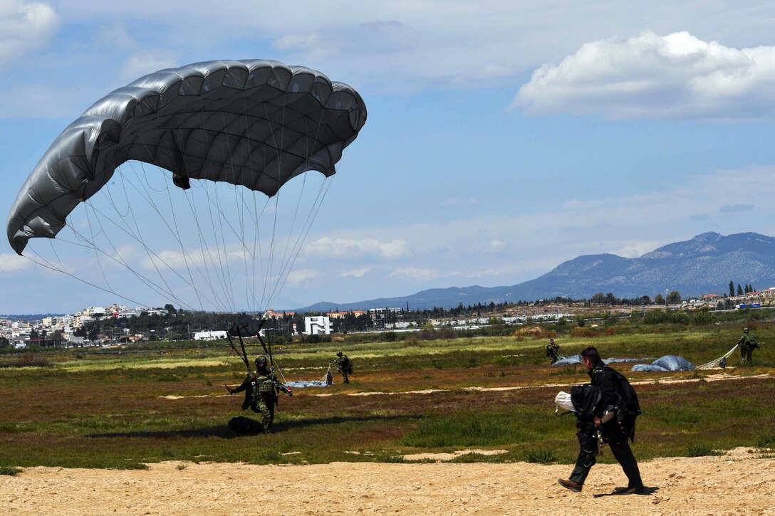 A Greek paratrooper lands at the drop zone after jumping from a U.S. Air Force C-130J Super Hercules near Megara, Greece, April 22, 2017. Approximately 80 paratroopers exited from two C-130s during static-line and free-fall jumps. As NATO allies, the U.S. and Greece share a commitment to promote peace and stability, and seek opportunities to continue developing their strong relationship. Air Force photo by Senior Airman Tryphena Mayhugh