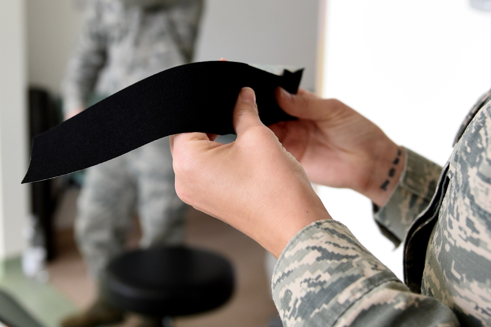 Students test the elasticity of kinesio tape during the recent medical group training day at Spangdahlem Air Base, Germany, April 21, 2017. Kinesio taping is a procedure intended to decrease pain and inflammation, stimulate blood and lymph circulation, aid postural correction, enhance athletic performance and prevent musculoskeletal injuries. (U.S. Air Force photo by Tech. Sgt. Staci Miller)