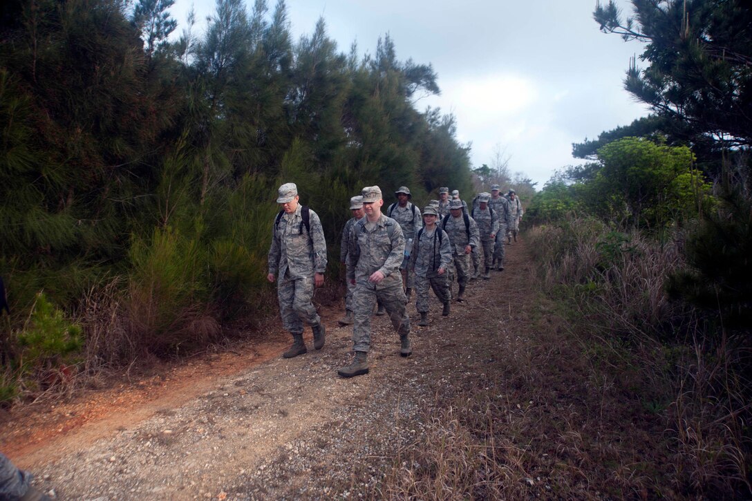 U.S. airmen hike to an exercise location on Kadena Air Base, Japan, April 21, 2017. The preventative aerospace medicine convention includes training on factors affecting the placement of dining facilities, latrines and other necessary amenities in deployed environments. Air Force photo by Airman 1st Class Quay Drawdy