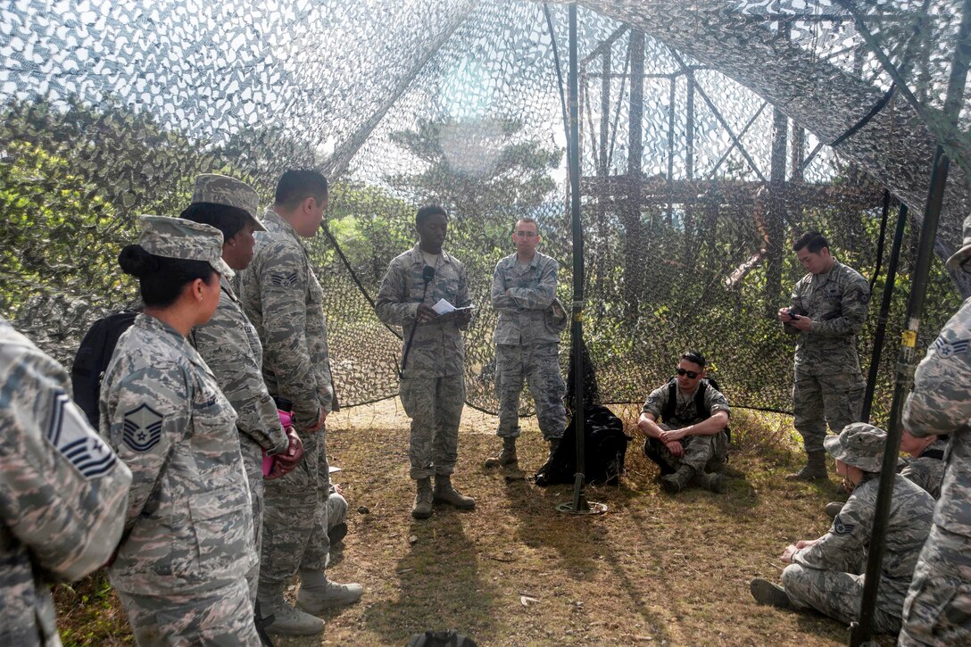 Air Force Senior Airman Isiah Fleming, center, briefs airmen during the preventative aerospace medicine convention on Kadena Air Base, Japan, April 21, 2017. Air Force photo by Airman 1st Class Quay Drawdy