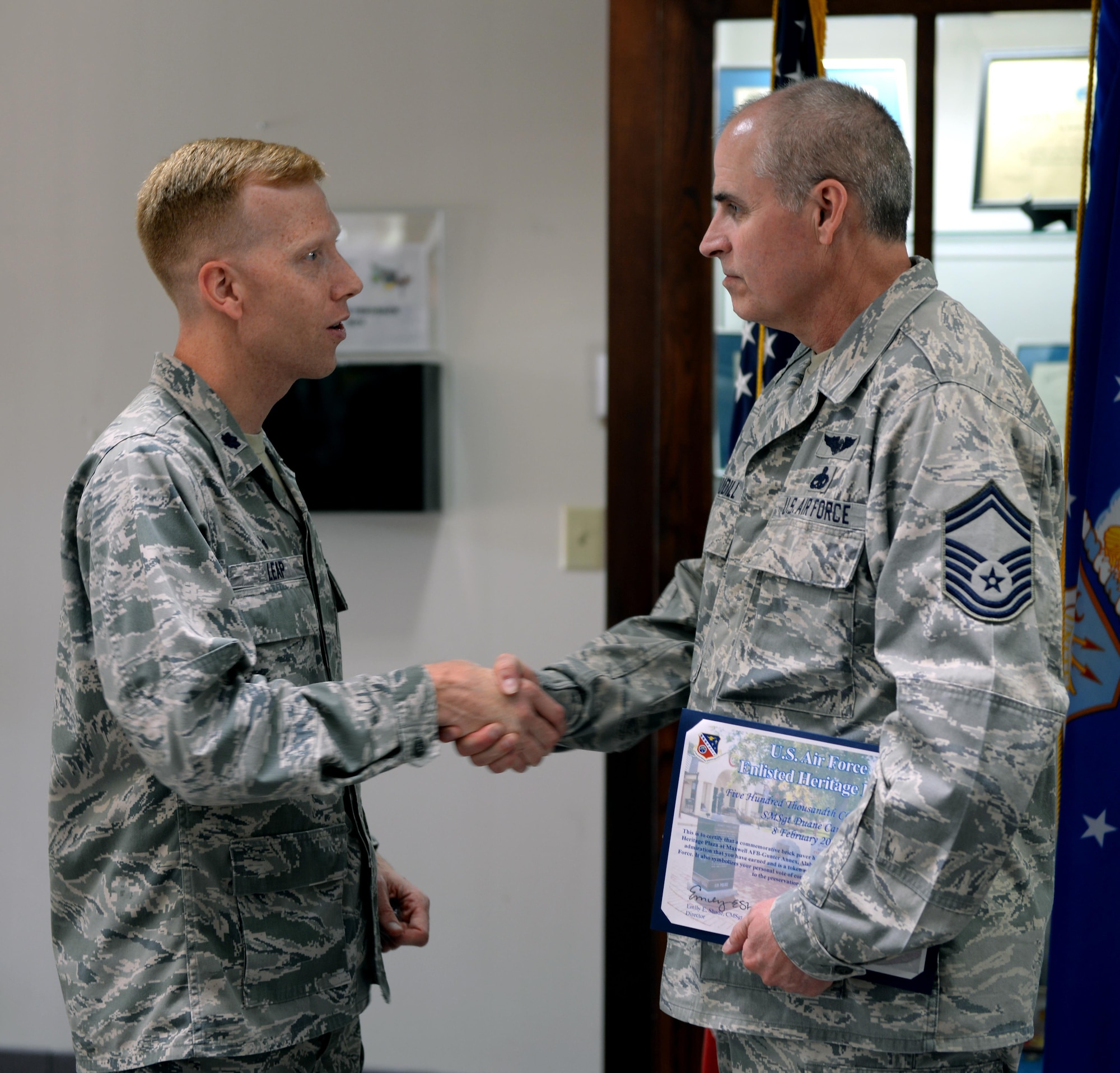 Lt. Col. Nathan Leap, Community College of the Air Force Commandant, presents Senior Master Sgt. Duane Caudill, 302nd Maintenance Group career advisor, with his CCAF degree on Maxwell Air Force Base, Ala., April 21, 2017. Caudill is the 500,000th graduate of the CCAF. It only took Caudill six months to complete the final steps of reaching his goals and obtaining his CCAF degree. (U.S. Air Force photo/Senior Airman Tammie Ramsouer)