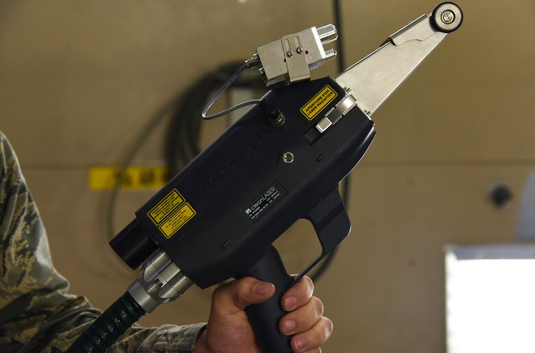 Staff Sgt. Bennie E. Rizzo III, 60th Maintenance Squadron aircraft structural supervisor, presents the new Nd:YAG laser at Travis Air Force Base, Calif., April 10, 2017. The laser will decrease hazardous waste created from traditional removal of paint, primer, corrosion and rust. (U.S. Air Force photo by Senior Airman Sam Salopek)