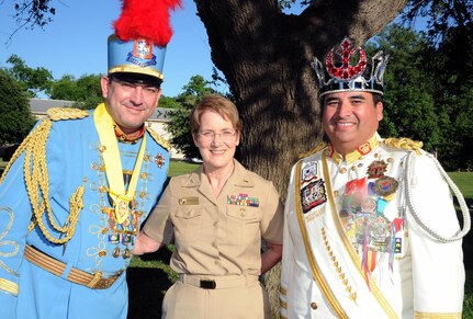 Rear Adm. Rebecca McCormick-Boyle (center), commander of Navy Medicine Education, Training and Logistics Command, is flanked by King Antonio Michael A. Casillas  (left) and El Rey Feo LXIX Fred Reyes (right) during a reception for Fiesta and Fireworks at Joint Base San Antonio-Fort Sam Houston April 23.