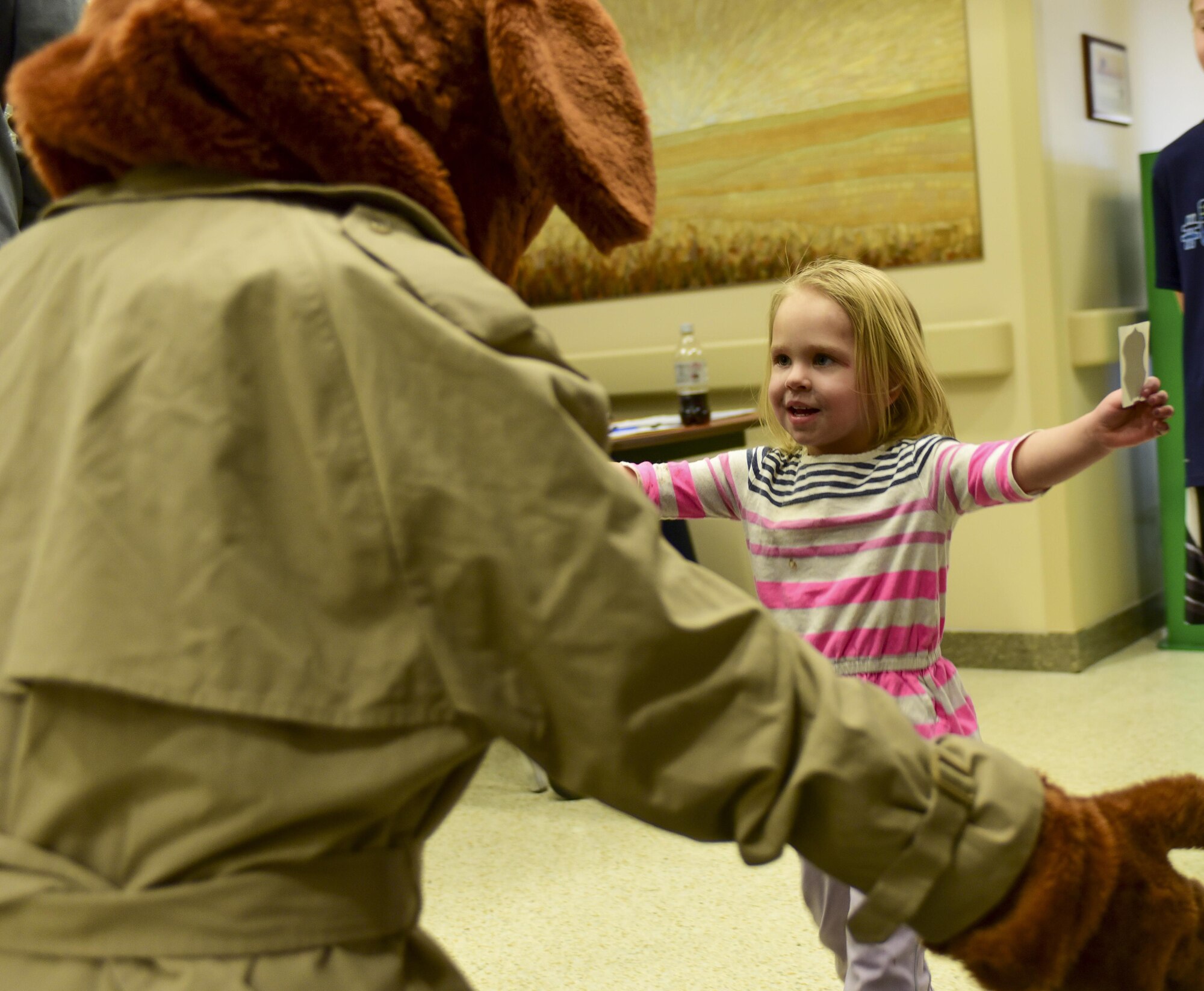 Alexa Henriksen runs to give McGruff the Crime Dog a hug during the 2017 Children’s Fair inside the 28th Medical Group at Ellsworth Air Force Base, S.D., April 20, 2017. McGruff the Crime Dog and Sparky the Fire Dog participated in the Children’s Fair to raise awareness for Child Abuse Prevention Awareness Month. (U.S. Air Force photo by Airman 1st Class Randahl J. Jenson)  