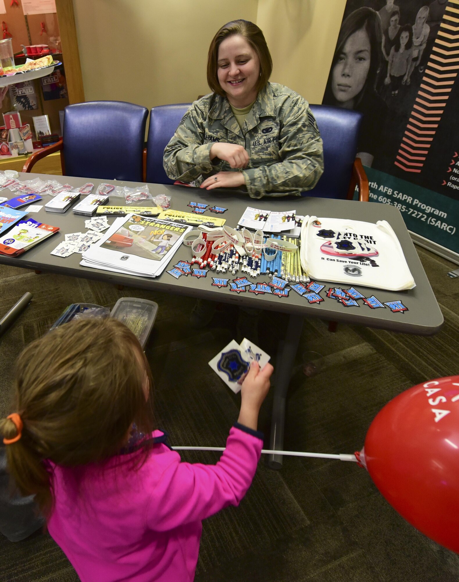 Aniah Perry receives stickers from Staff Sgt. Casey Williams, a defender assigned to the 28th Security Forces Squadron, during the 2017 Children’s Fair inside the 28th Medical Group at Ellsworth Air Force Base, S.D., April 20, 2017. Airmen from the 28th SFS, 28th Civil Engineer Squadron and 28th Medical Group volunteered for the event to support Child Abuse Prevention Awareness Month. (U.S. Air Force photo by Airman 1st Class Randahl J. Jenson) 