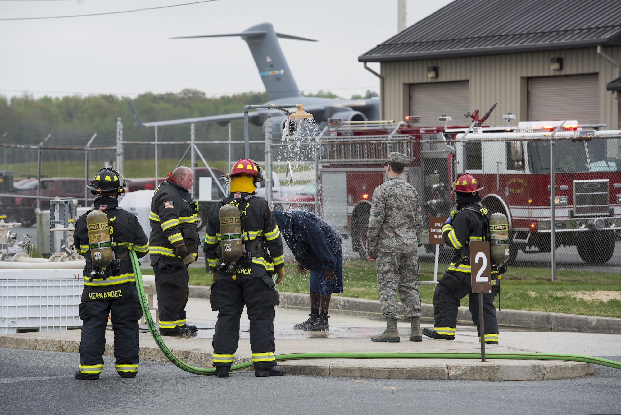 Firefighters assigned to the 436th Civil Engineer Squadron operate an emergency shower to remove simulated Jet-A fuel from a person who feigned full-body exposure during a fuel spill exercise April 20, 2017, at Dover Air Force Base, Del. After showering, members exposed to dermal contact with jet fuel or other hazardous materials require immediate medical evaluation and treatment. (U.S. Air Force photo by Senior Airman Aaron J. Jenne)