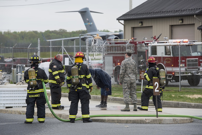 Firefighters assigned to the 436th Civil Engineer Squadron operate an emergency shower to remove simulated Jet-A fuel from a person who feigned full-body exposure during a fuel spill exercise April 20, 2017, at Dover Air Force Base, Del. After showering, members exposed to dermal contact with jet fuel or other hazardous materials require immediate medical evaluation and treatment. (U.S. Air Force photo by Senior Airman Aaron J. Jenne)