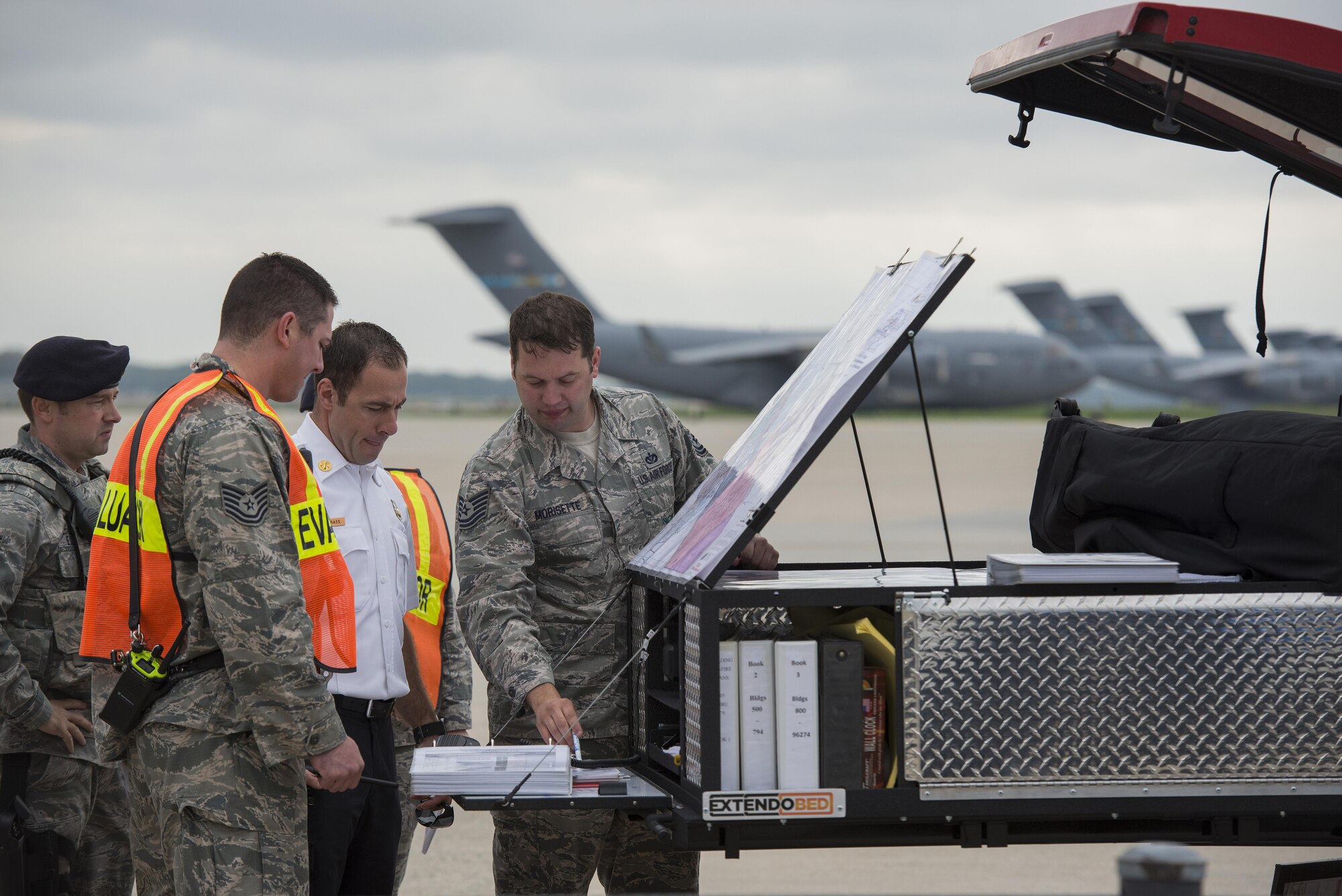 Tech. Sgt. Scott Morisette (right), 436th Civil Engineer Squadron Fire Department NCO in charge of logistics, plans emergency response during a fuel spill exercise April 20, 2017, at a temporary command center on Dover Air Force Base, Del. Morisette acted as the on-scene commander to coordinate emergency response and fuel containment efforts. (U.S. Air Force photo by Senior Airman Aaron J. Jenne)