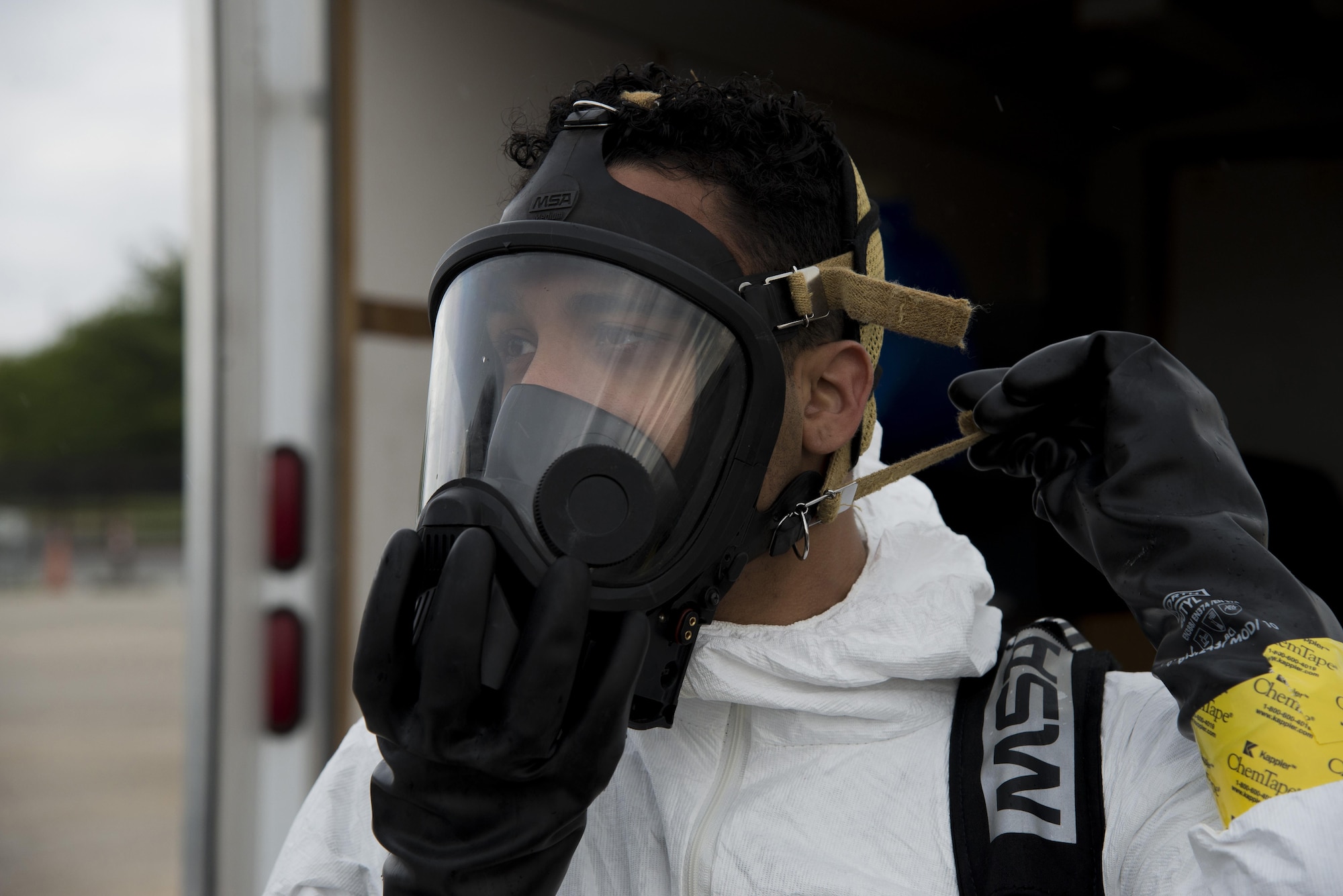 Senior Airman Jorge Rijo, 436th Aerospace Medicine Squadron bioenvironmental engineering technician, adjusts his respirator during a fuel spill exercise April 20, 2017, at Dover Air Force Base, Del. Rijo and a coworker prepared to measure air quality at the site of a simulated fuel spill. (U.S. Air Force photo by Senior Airman Aaron J. Jenne)