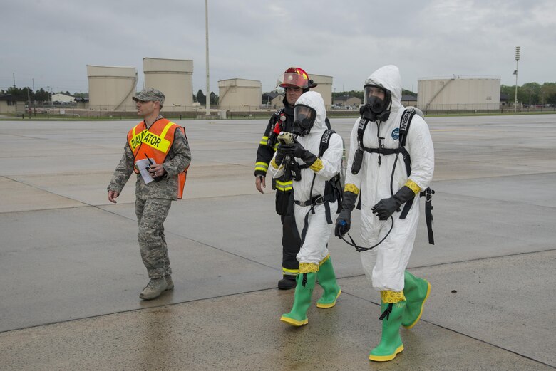 Emergency responders assigned to the 436th Airlift Wing investigate a simulated large-volume fuel spill during an exercise April 20, 2017, at Dover Air Force Base, Del. The exercise simulated damage to a fuel silo, pictured in the background. These siloes are capable of holding millions of gallons of Jet-A fuel. (U.S. Air Force photo by Senior Airman Aaron J. Jenne)