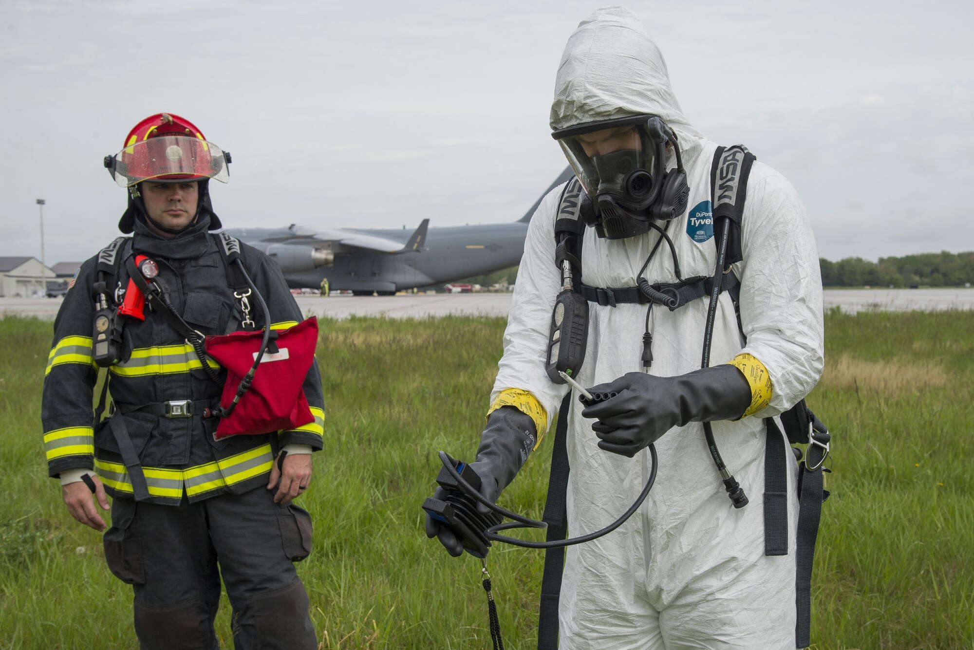 Tech. Sgt. Matthew Miiller, 436th Civil Engineer Squadron Fire Department crew chief, provides communication support as Senior Airman Alexander Delfs, 436th Aerospace Medicine Squadron bioenvironmental engineering technician, uses a Draegar Civil Defense Simultest Kit to measure airborne hydrocarbons at the scene of a simulated fuel spill during an exercise April 20, 2017, near a flightline drainage spill gate on Dover Air Force Base, Del. Bioenvironmental engineering technicians provide various hazmat response capabilities around the Air Force. (U.S. Air Force photo by Senior Airman Aaron J. Jenne)