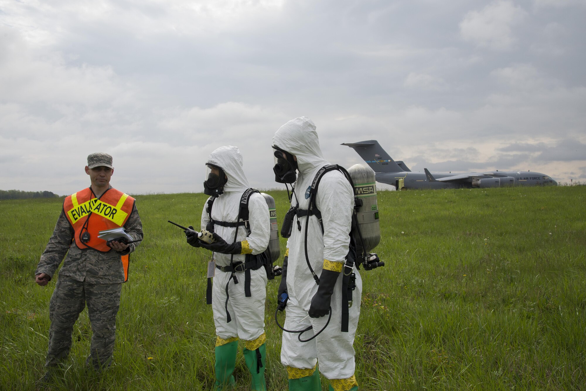From left, Tech. Sgt. Jeffry Stamm, 436th Aerospace Medicine Squadron Bioenvironmental Engineering flight chief, provides simulated air quality values with Senior Airmen Jorge Rijo and Alexander Delfs, bioenvironmental engineering technicians, during a fuel spill exercise April 20, 2017, near a flightline drainage spill gateon Dover Air Force Base, Del. Rijo relayed the simulated values via radio to the temporary control center, which acted as a communication hub between emergency responders and other installation command agencies. (U.S. Air Force photo by Senior Airman Aaron J. Jenne)