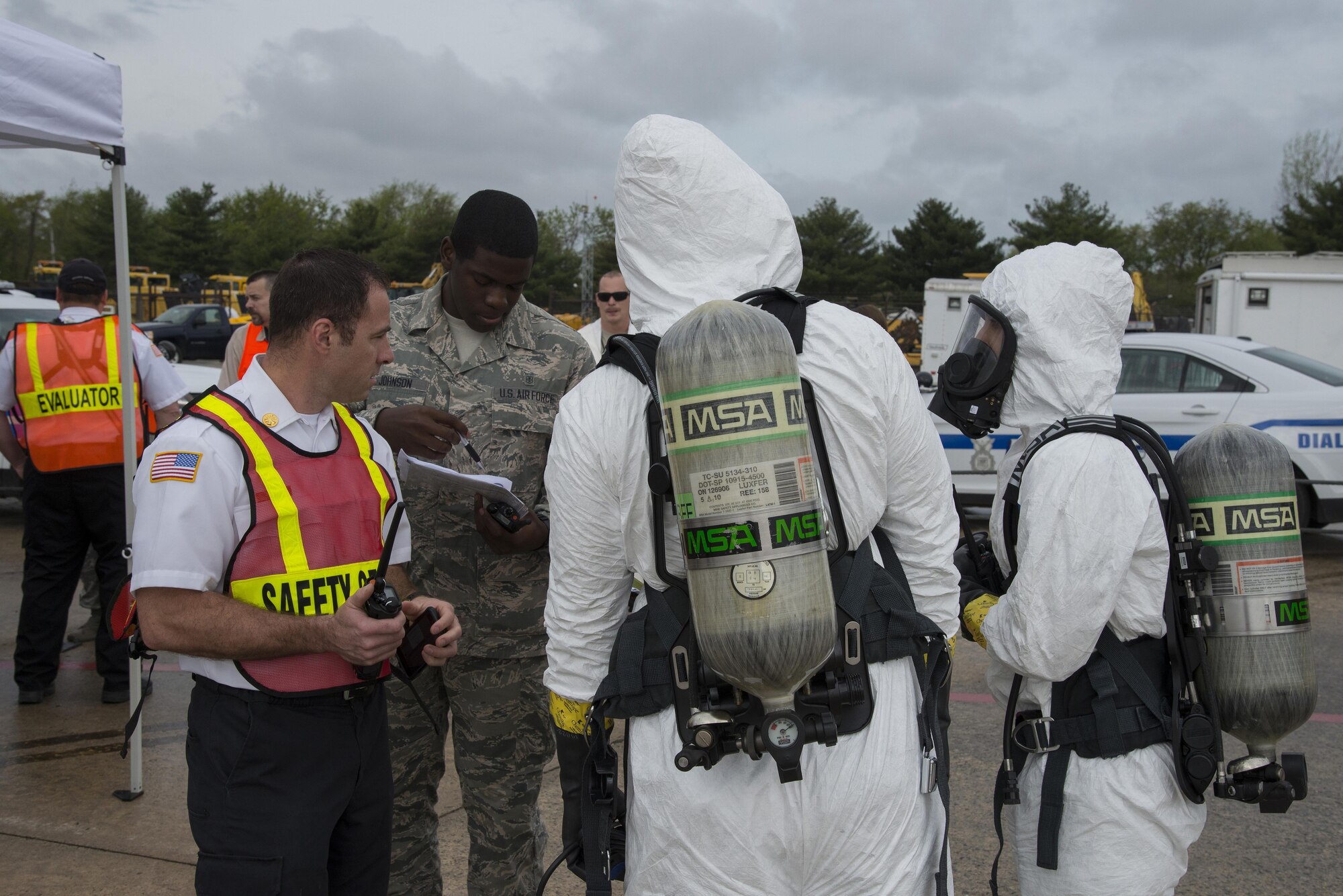 Thomas Krass, 436th Civil Engineer Squadron Fire Department assistant fire chief, debriefs Senior Airmen Alexander Delfs and Jorge Rijo, 436th Aerospace Medicine Squadron bioenvironmental engineering technicians, at a temporary command center during a fuel spill exercise April 20, 2017, at Dover Air Force Base, Del. The bioenvironmental engineers relayed pertinent information about the simulated fuel spill, which allowed the on-scene commander to make informed command decisions. (U.S. Air Force photo by Senior Airman Aaron J. Jenne)