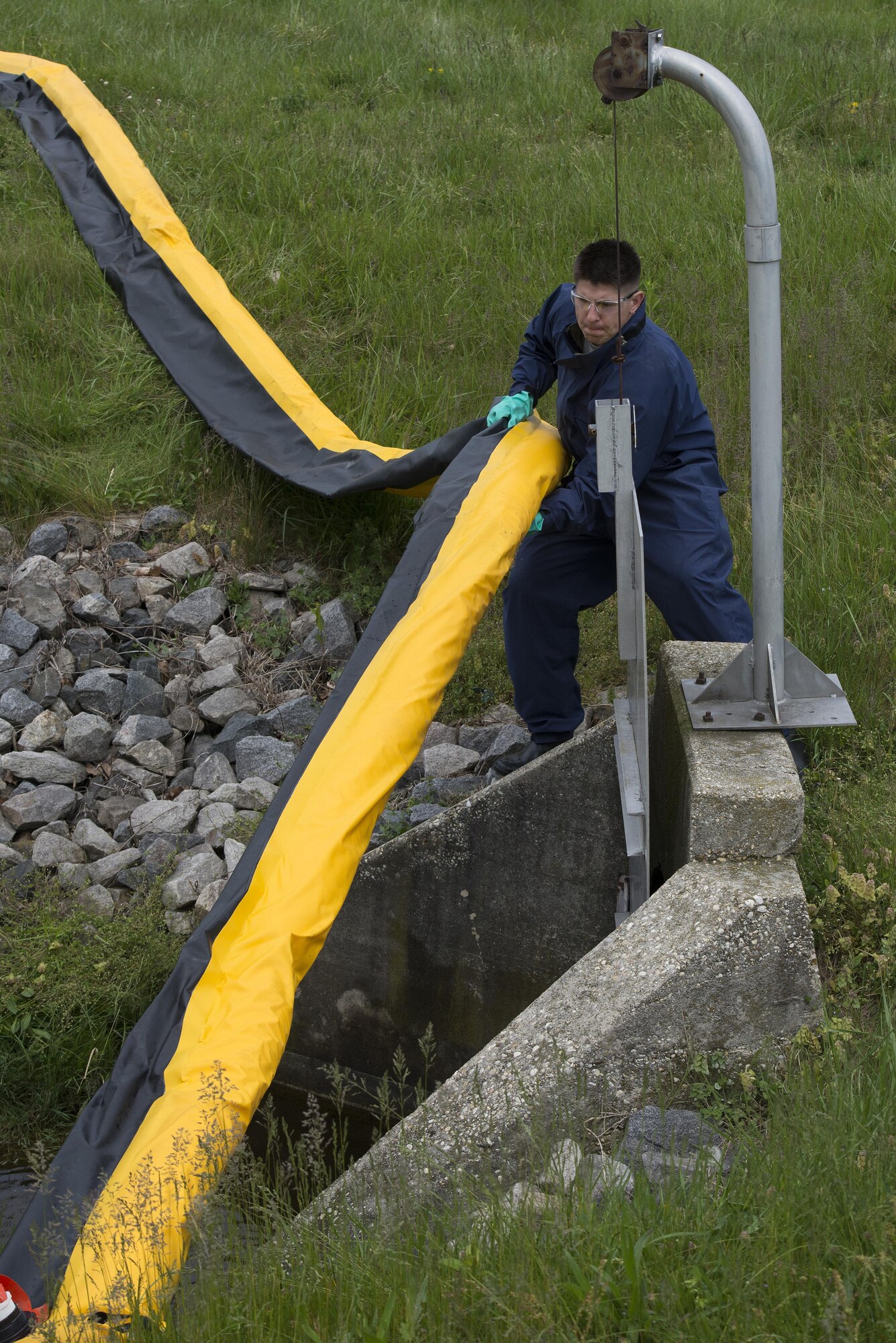 Staff Sgt. Robert Simpson, 436th Civil Engineer Squadron Infrastructure and Utilities water and fuel systems maintenance technician, adjusts a containment boom at a flightline drainage spill gate during a fuel spill exercise April 20, 2017, at Dover Air Force Base, Del. Along with the containment boom, Team Dover’s emergency responders would also close the drainage gate during a real-world emergency. (U.S. Air Force photo by Senior Airman Aaron J. Jenne)