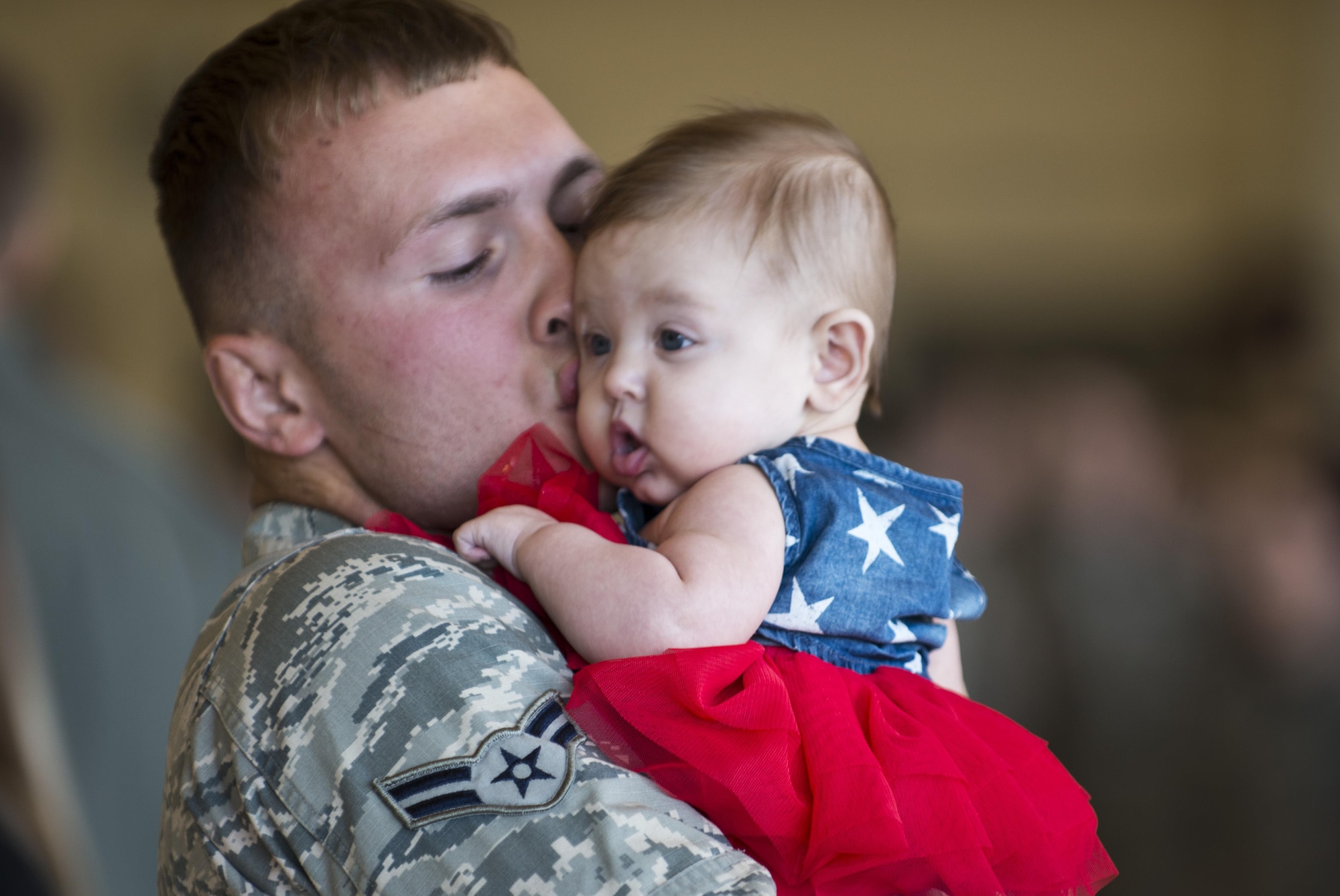Airman 1st Class Carl Runkel, a munitions crew member with the 3rd Maintenance Group hugs his three-month-old daughter Korra Storm after seeing her for the first time at Hangar 25 on Joint Base Elmendorf-Richardson, Alaska April 21 upon returning from a 7-month deployment. For many families, this was their first time being separated from their loved ones for an extended period of time.