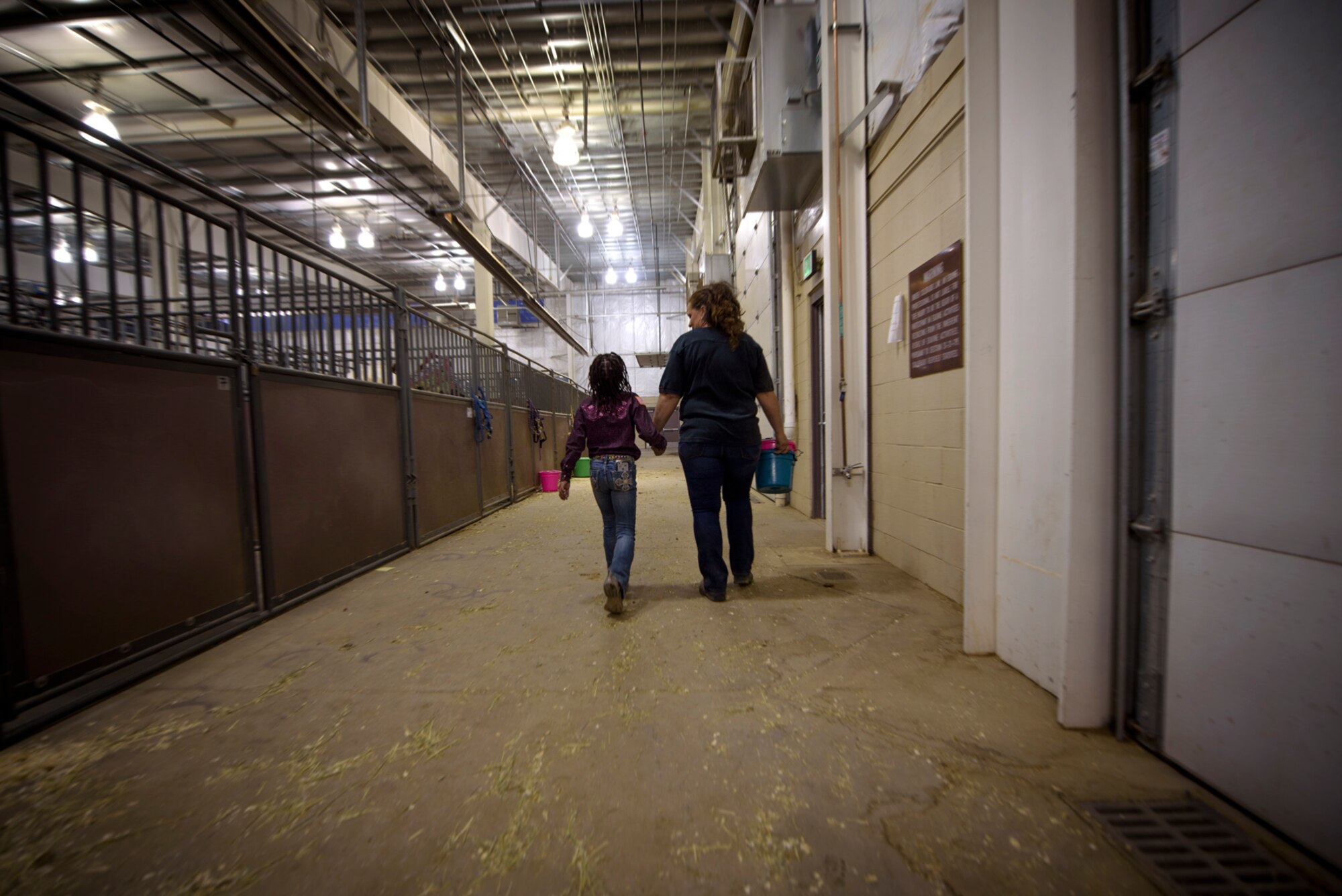 Lt. Col. Nicole Roberts, 21st Security Forces Squadron commander, holds hands with her daughter, Savannah, at a barrel racing event in Loveland, Colo., April 15, 2017. Roberts supports her daughters’ dreams of competing in professional rodeo events just as they support her and her military career. (U.S. Air Force photo by Airman 1st Class Dennis Hoffman)