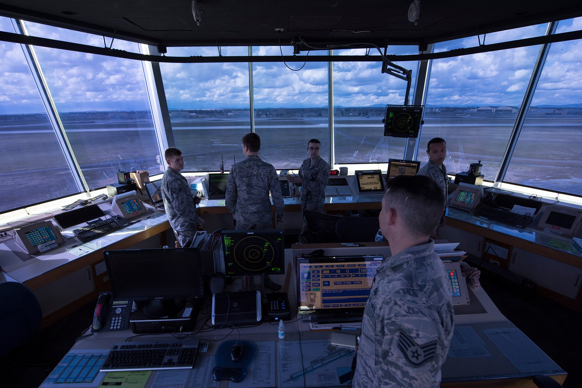 Airmen from the 92nd Operations Support Squadron air traffic control tower, respond to the direction of the watch supervisor in preperation for an incoming aircraft Apr. 18, 2017, at Fairchild Air Force Base, Washington. The control tower is manned by by four positions, flight data, ground control, local control and watch supervisor. (U.S. Air photo/Airman 1st Class Ryan Lackey)