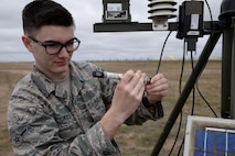 Airman Connor McDonald, 5th Operations Support Squadron weather forecaster, inspects the rain gauge on the Deployed Tactical Meteorological Observing System (TMQ-53) at Minot Air Force Base, N.D., April 18, 2017. Weather forecasters check the rain gauge every three hours and drain it out every six hours. (U.S. Air Force photos/Airman 1st Class Dillon Audit)