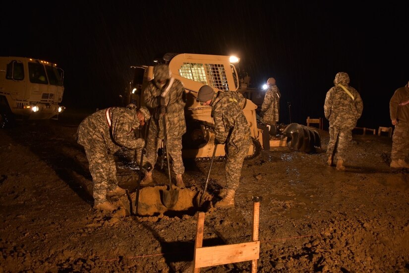 Soldiers of 1223rd Engineer Company, 778th Engineer Battalion, South Carolina Army National Guard, dig 36”x36”x36” post holes for the Multi-Purpose Covered Shelter at Cincu Training Area, Romania, on 19 April 2017. This exercise tested their proficiency in night-time engineering operations. The project is a part of Resolute Castle 17, an exercise which strengthens the NATO alliance and enhances its capacity to quickly respond to threats within the region. (US Army photo by Capt. Colin J. Cutler, 926th Engineer Brigade)