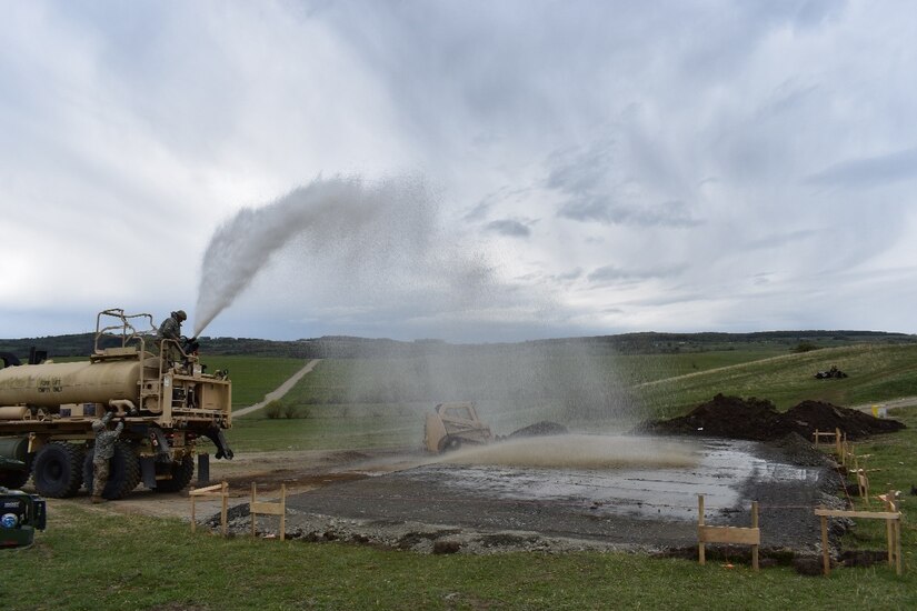 Cpl. Trevor Lottinville and Staff Sgt. John Morgan of 390th Engineer Company, 844th Engineer Battalion out of Chattanooga, TN, spray down the base layer for the Multi-Purpose Covered Shelter at Cincu Training Area, Romania, on 19 April 2017. The project is a part of Resolute Castle 17, an exercise which strengthens the NATO alliance and enhances its capacity to quickly respond to threats within the region. (US Army photo by Capt. Colin J. Cutler, 926th Engineer Brigade)