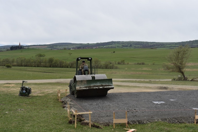 Sgt. Jesse Ellis, a heavy equipment operator of 390th Engineer Company, 844th Engineer Battalion out of Chattanooga, TN, levels and grades the base layer for the multipurpose building with a roller on 19 April 2017 at Cincu Training Area, Romania. This establishes a solid footing for the concrete pad that will be the floor of the building. The project is a part of Resolute Castle 17, an exercise which strengthens the NATO alliance. (US Army photo by Capt. Colin J. Cutler, 926th Engineer Brigade)