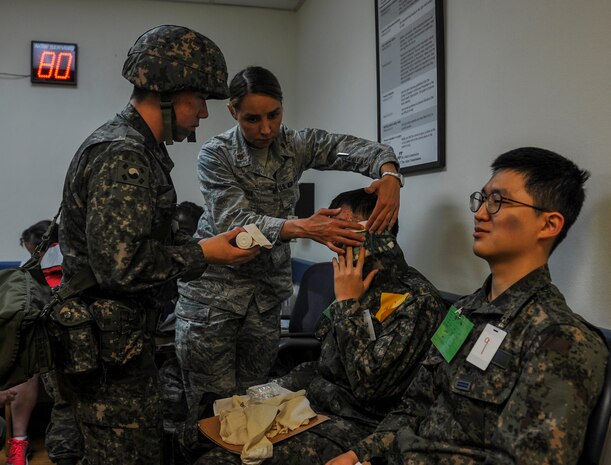 U.S. Air Force Maj. Anna Fedotova, 8th Medical Operation Squadron mental health flight chief, and a Republic of Korea Air Force (ROKAF) medical airman work together to bandage a ROKAF airman’s head during a mass casualty (MASCAL) exercise at Kunsan Air Base, Republic of Korea, April 19, 2017. The combined training gave first responders valuable experience and helped strengthen the relationship between U.S. and ROKAF medical units. 