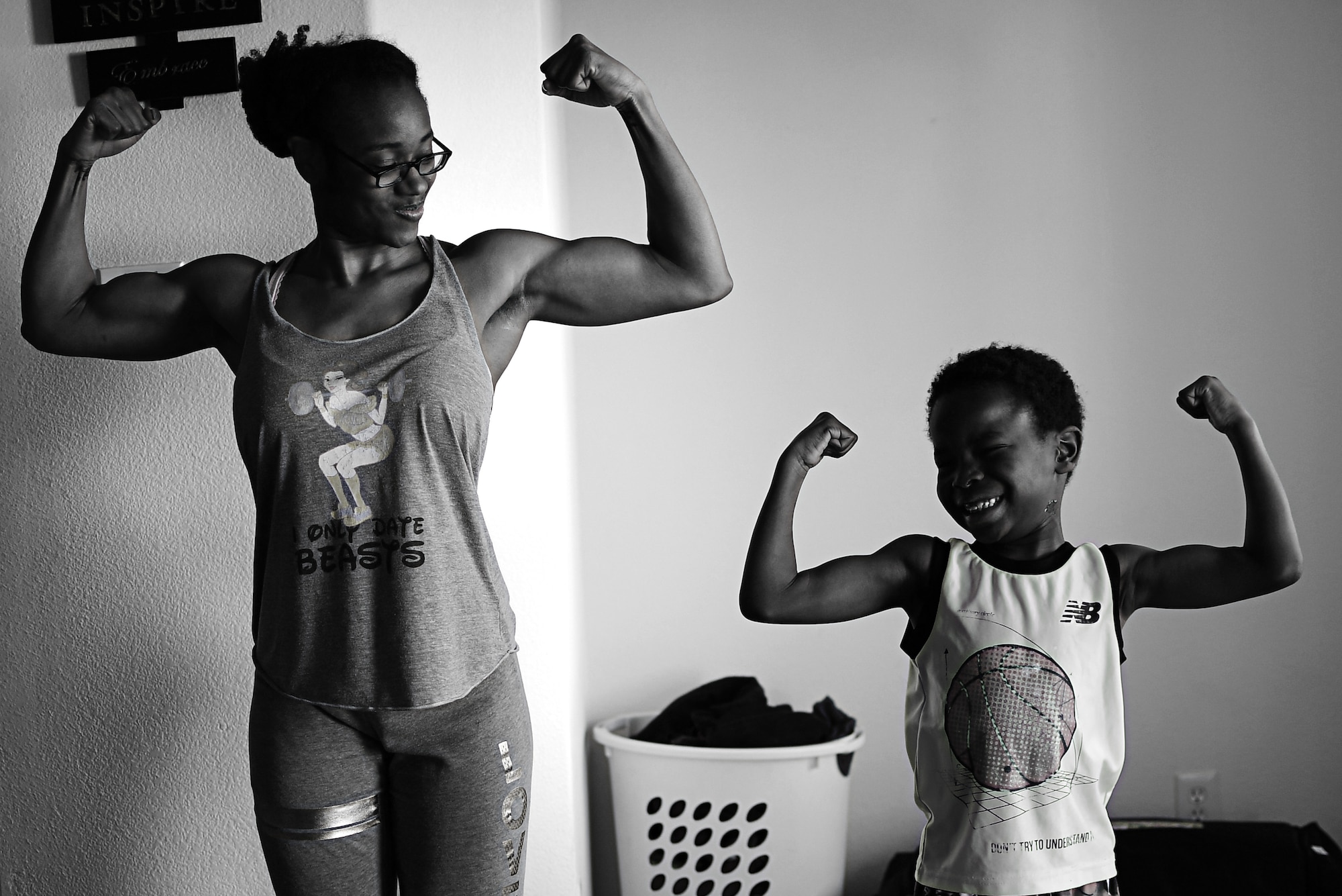 Semaj, 432nd Aircraft Maintenance Squadron supply craftsman, and her son Jamel, 6, strike a muscle pose April 2, 2017, at their home in Las Vegas. Semaj recently took second place in the 2017 National Physique Committee Southern Championships in the figure category. She is now a nationally qualified amateur bodybuilder seeking her professional card. (U.S. Air Force photo/Senior Airman Christian Clausen)
