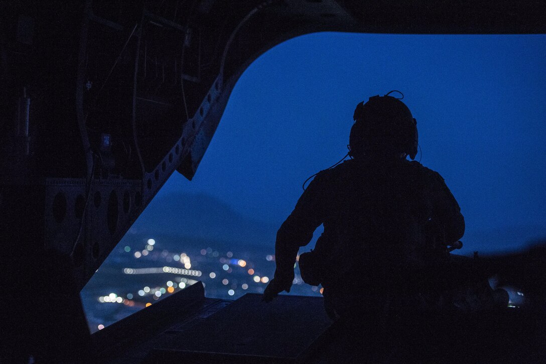 A CH-47 Chinook helicopter crew chief keeps watch during a flight over Kabul, Afghanistan, April 24, 2017. The helicopter was carrying Defense Secretary Jim Mattis as he visited the country. DoD photo by U.S. Air Force Tech. Sgt. Brigitte N. Brantley