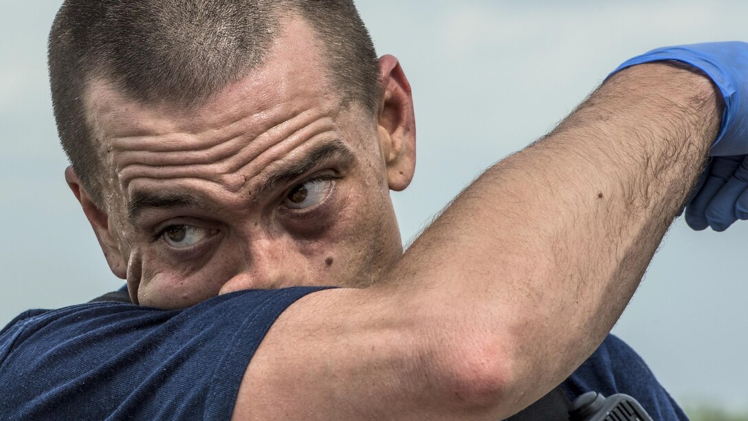 Air Force Senior Airman Andrew Brock wipes sweat from his face after tending to simulated injured patients during an air show incident response training exercise at Scott Air Force Base, Ill., April 20, 2017. Air Force photo by Staff Sgt. Jodi Martinez