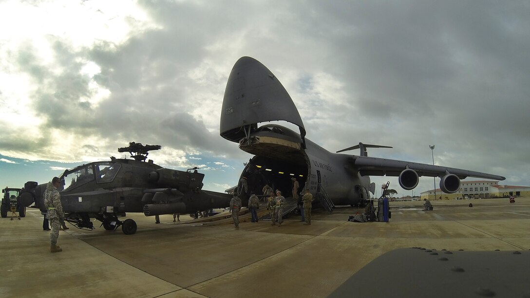 An AH-64 Apache helicopter is unloaded from a Team Dover C-5M Super Galaxy airlifter March 26, 2017, at Naval Station Rota, Spain. The aircrews were comprised of Airmen from the 9th and 709th Airlift Squadrons. (Courtesy photo)
