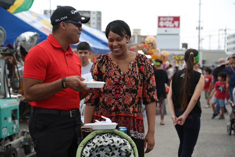 CAMP FOSTER, OKINAWA, Japan – A couple enjoys Jamaican jerk food April 23 at the Camp Foster Festival in Okinawa, Japan. Foster Fest is a free, annual event that is open to the military community and local residents. The festival featured magic shows, kid friendly concerts and assorted games. (U.S Marine photo by Lance Corporal Tayler P. Schwamb)