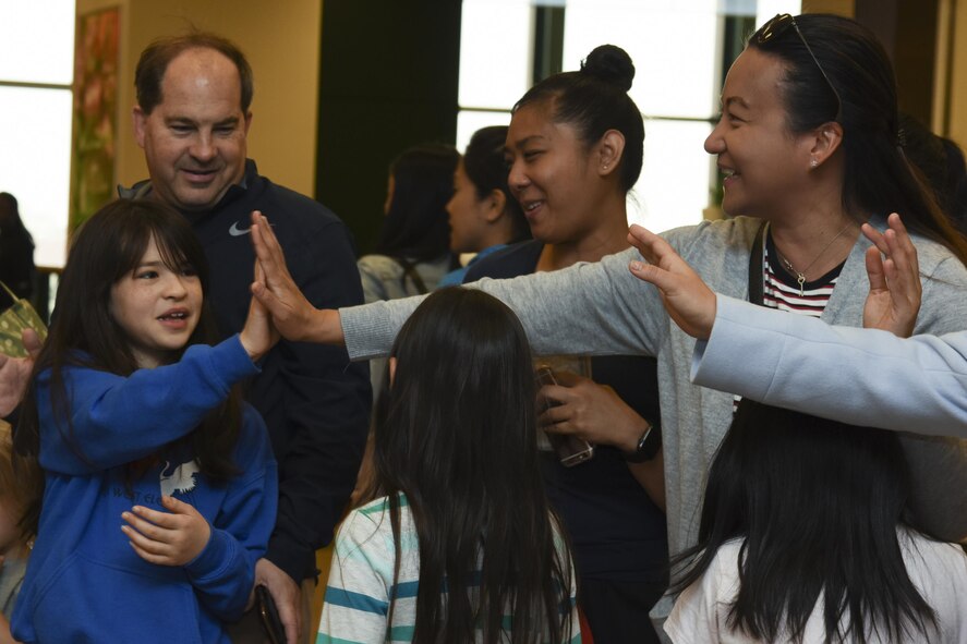 First place winner of the group category exchanges a high-five with teachers after winning the Recycled Art Contest April 22, 2017, at Yokota Air Base, Japan. The 374th Civil Engineer Squadron hosted the Recycled Art Contest as part of the Earth Day eco-friendly activities. The art works were constructed of used recyclable materials and the winners were selected from 374 votes in one of three categories: group, class and individual. (U.S. Air Force photo by Machiko Arita)