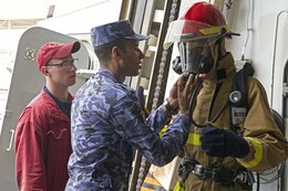 Damage Controlman 2nd Class Cody Osgood observes as Egyptian Navy Sailors put on firefighting equipment during Damage Control (DC) Olympics onboard guided-missile destroyer USS Truxtun (DDG 103) as part of Exercise Eagle Salute 17. Eagle Salute/Eagle Response 17 is a multilateral exercise with Egypt, Saudi Arabia and United Arab Emirates to enhance mutual capabilities in maritime security operations. Truxtun is deployed to the U.S. 5th Fleet area of operations in support of maritime security operations designed to reassure allies and partners and preserve the freedom of navigation and the free flow of commerce in the region. 