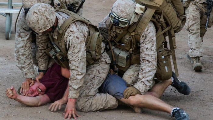 Marines supporting Marine Aviation Weapons and Tactics Squadron 1 subdue a role player during Assault Support Tactics 3, supporting the semiannual Weapons and Tactics Instructor Course 2-17 at Marine Corps Air Station Yuma, Arizona, April 21. Lasting seven weeks, WTI is a training evolution hosted by MAWTS-1 which provides standardized advanced and tactical training and certification of unit instructor qualifications to support Marine aviation training and readiness. The AST-3 training focused on conducting noncombatant evacuation operations in an urban environment while providing foreign humanitarian assistance to the simulated host nation.
