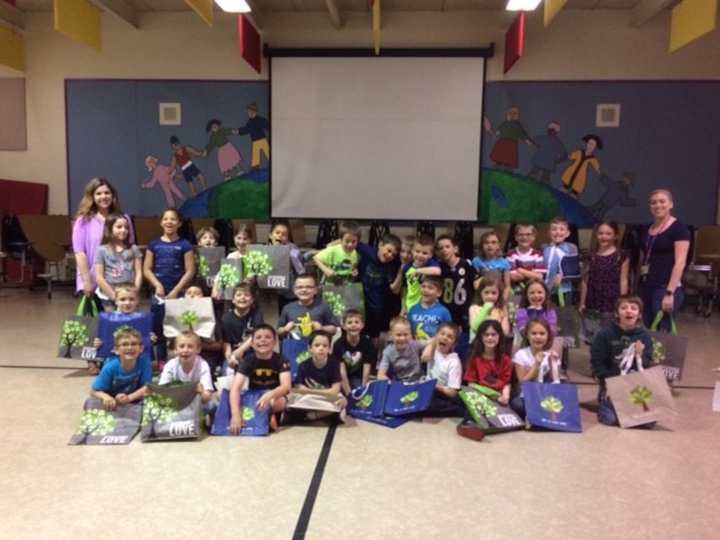 Students from Fairview Elementary pose with their new reusable bags after an Earth Day event hosted by Sarah Moor, environmental protection specialist with DLA Installation Support for Distribution.