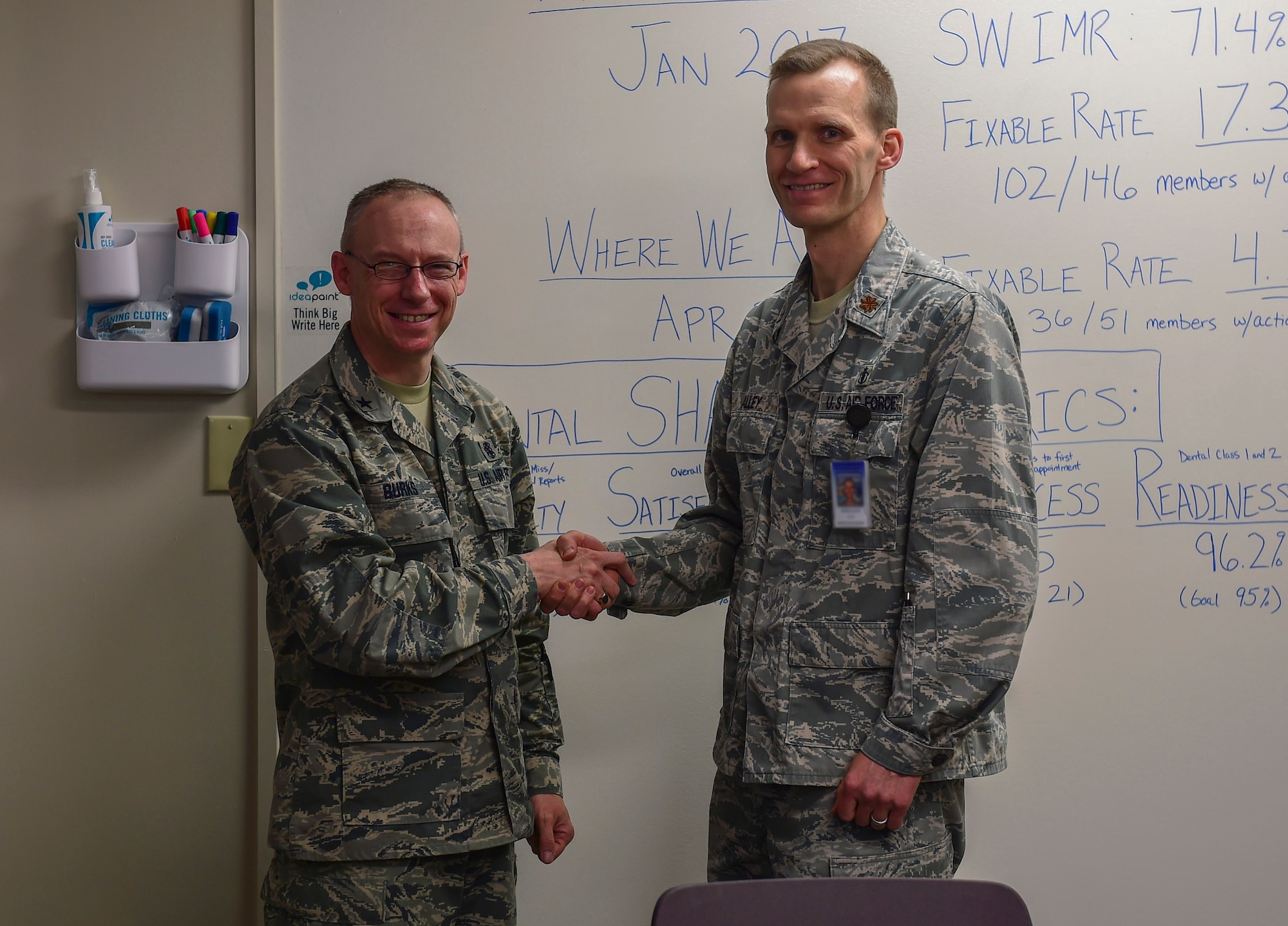 Brig. Gen. James Burks, Director, Manpower, Personnel, and Resources Corps Chief, Medical Service Corps, coins Maj. Merrill Alley, 460th Medical Operations Squadron dental flight commander, April 25, 2017, on Buckley Air Force Base, Colo. Burks toured the medical facilities on base and was briefed the status of each unit. (U.S. Air Force photo by Airman Jacob Deatherage/Released)
