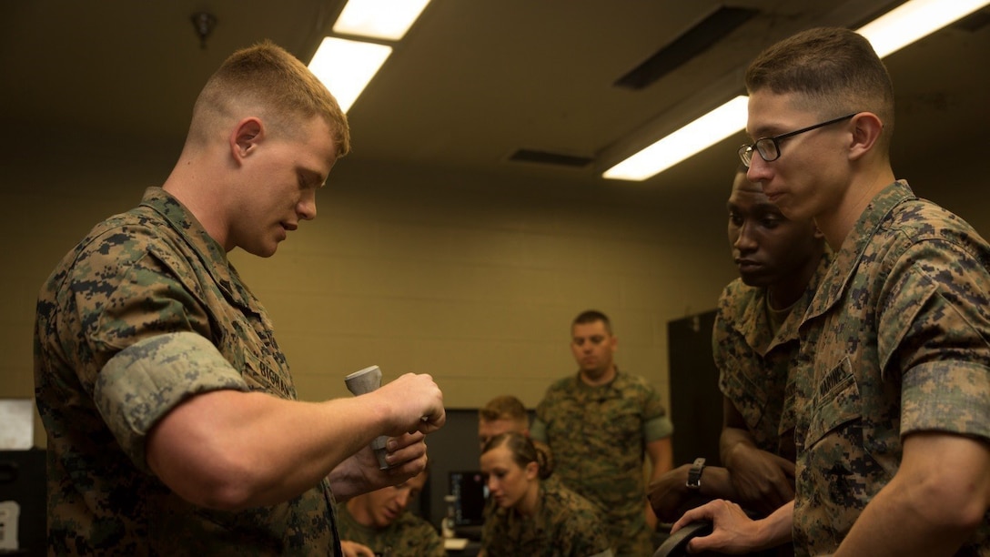 Cpl. Christopher A. Bigham (left), an instructor for the 3-D Printing Training Course and a machine shop noncommissioned officer with General Support Maintenance Company, 2nd Maintenance Battalion, Combat Logistics Regiment 25, 2nd Marine Logistics Group, demonstrates how to use calipers during a reverse engineering class at Marine Corps Base Camp Lejeune, North Carolina, April 20, 2017. Marines from various sections of Special Purpose Marine Air-Ground Task Force - Southern Command attended the two-day training hosted by GSM Co., 2nd Maint. Bn., CLR 25, 2nd MLG, in order to gain hands-on experience with 3-D printers and receive instruction in computer-aided design, file creation and manufacturing.