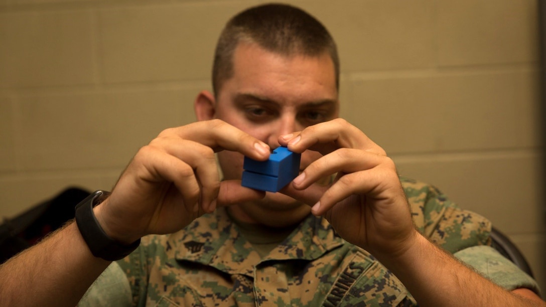 Sgt. Andrew J. Miller, an embarkation chief with the Command Element, Special Purpose Marine Air-Ground Task Force - Southern Command, inspects a three-dimensional printed line block during the 3-D Printing Training Course at Marine Corps Base Camp Lejeune, N.C., April 20, 2017. Marines from various sections of SPMAGTF-SC attended the two-day training hosted by General Support Maintenance Company, 2nd Maintenance Battalion, Combat Logistics Regiment 25, 2nd Marine Logistics Group, in order to gain hands-on experience with 3-D printers and receive instruction in computer-aided design, file creation and manufacturing. (U.S. Marine Corps photo by Sgt. Ian Leones)