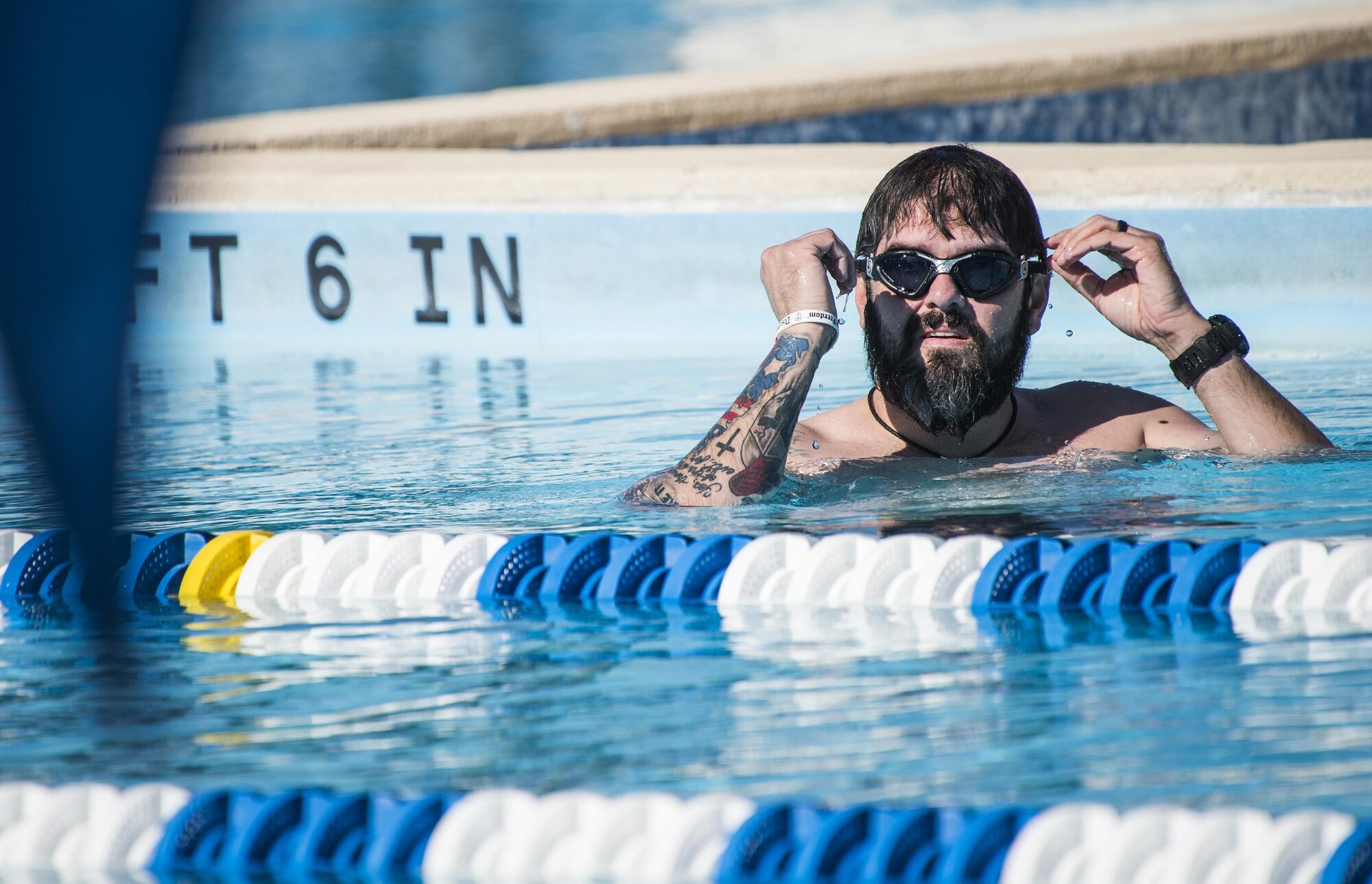Aaron Allman, A Warrior CARE athlete, adjusts his goggles between laps during a swim session at the adaptive sports camp at Eglin Air Force Base, Fla., April 25. The base hosts the week-long Wounded Warrior CARE event that helps recovering wounded, ill and injured military members through specific hand-on rehabilitative training. (U.S. Air Force photo/Ilka Cole)