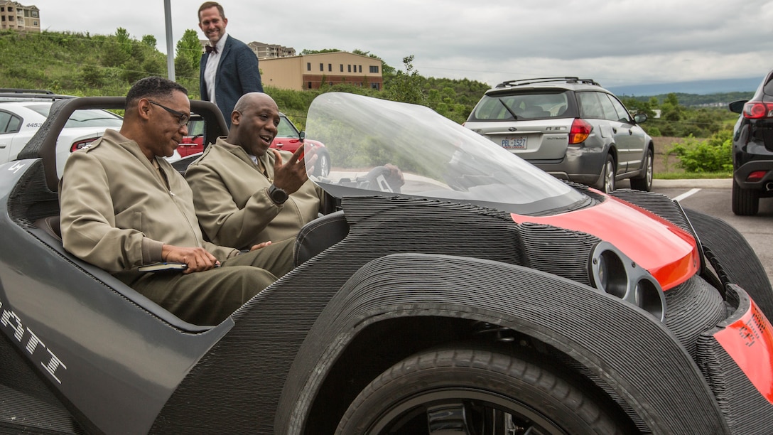 Sergeant Major of the Marine Corps Sgt. Maj. Ronald L. Green, right, and Maj. Gen. Craig C. Crenshaw, commanding general of Marine Corps Logistics Command, ride in a 3D printed car at the Local Motors Microfactory, Knoxville, Tennessee, April 25, 2017. Green and Crenshaw along with Commandant of the Marine Corps Gen. Robert B. Neller visited to better understand innovative co-creation and manufacturing.