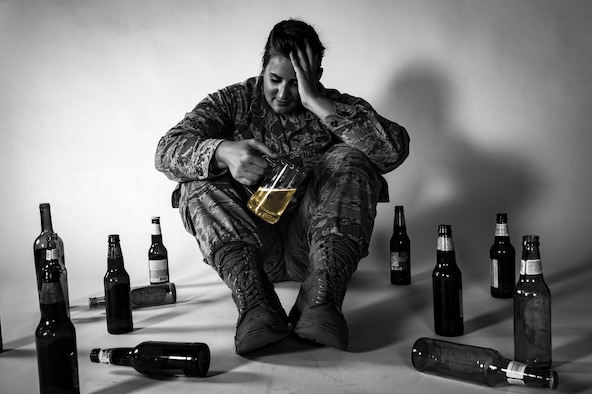 Airman 1st Class Mary Amstead, 23d Wing Judge Advocate general law paralegal, poses with an assortment of alcohol bottles, April 26, 2017, at Moody Air Force Base, Ga. The Air Force expresses the importance of having outlets for the stressors of military life. (U.S. Air Force illustration by Airman 1st Class Daniel Snider)