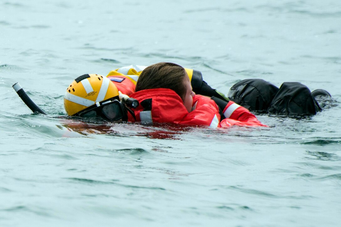 A Coast Guardsmen rescues a mock victim during a ocean rescue demonstration near Ventura, Calif., April 18, 2017. Coast Guard photos by Petty Officer 3rd Class DaVonte Marrow