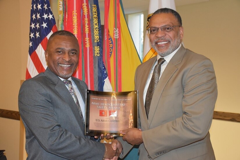 Eugene Collins (left), deputy assistant secretary of the Army (Environment, Safety and Occupational Health), presents the Fiscal 2016 Secretary of the Army and Chief of Staff, Army Headquarters Safety Award, to Norvel Turner, senior safety director, U.S. Army Central. As the higher headquarters, Turner accepted additional awards on behalf of the 1st Sustainment Command (Theater), 513th Military Intelligence (Theater) and Headquar-ters, Headquarters Battalion, USARCENT.