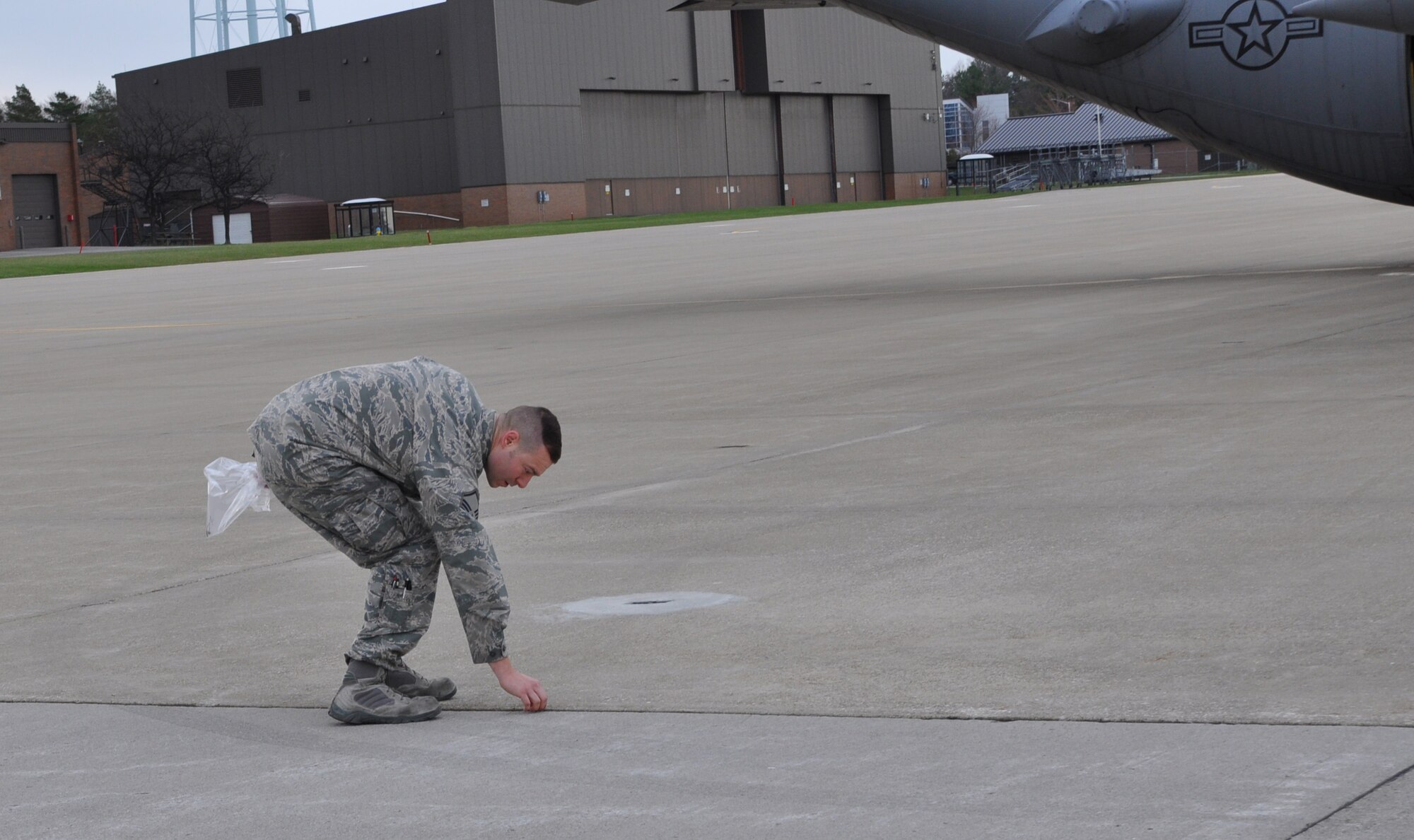 Master Sgt. James Johnson, 910th Maintenance Squadron Aerospace Propulsion Specialist, picks up a piece of foreign object debris (FOD) during the FOD walk on the flightline here, April 3, 2017. FOD walks are routinely held to clear the flightline of any objects alien to the area that could potentially cause damage to aircraft. Examples of FOD include broken pavement, wire bristles from snow removal equipment, trash and parts from ground vehicles. (U.S. Air Force photo/Maj. Polly Orcutt)
