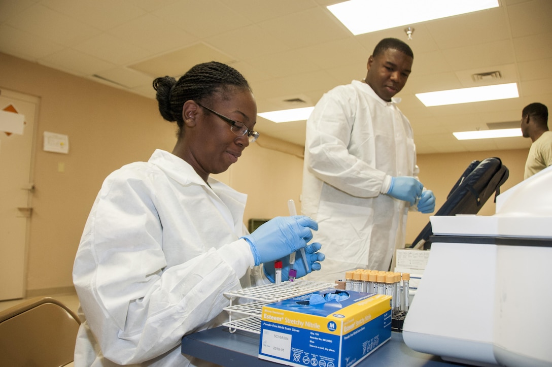 Army Pfc. Alexis Calloway and Spc. Emmanuel Elien, medical laboratory specialists assigned to the 440th Medical Detachment at Fort Bliss, Texas, prepare vials of blood for analysis, April 13, 2017. Army photo by Marcy Sanchez