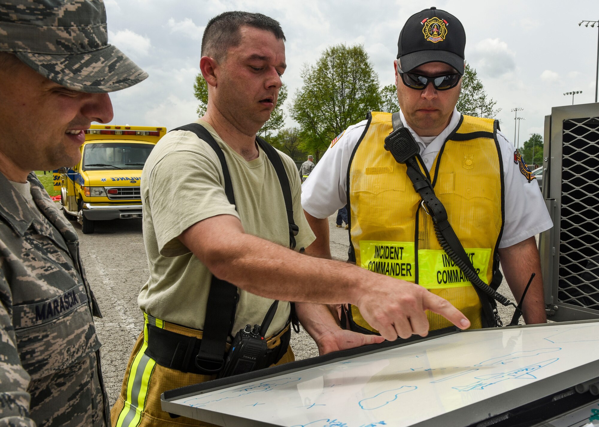 Chief Master Sgt. Michael Marascia, Tech. Sgt. Kyle Pourciau, and Eric Belland, 375th Civil Engineer Squadron firefighters, discuss the status of the simulated crash site where first responders were tested on their ability to react to an air show emergency, Scott Air Force Base, Ill., April 20, 2017.  The preparation comes before Scott Air Force Base’s first air show since 2012 and is in conjunction with the base’s 100th year anniversary. (U.S. Air Force photo by Staff Sgt. Jodi Martinez)