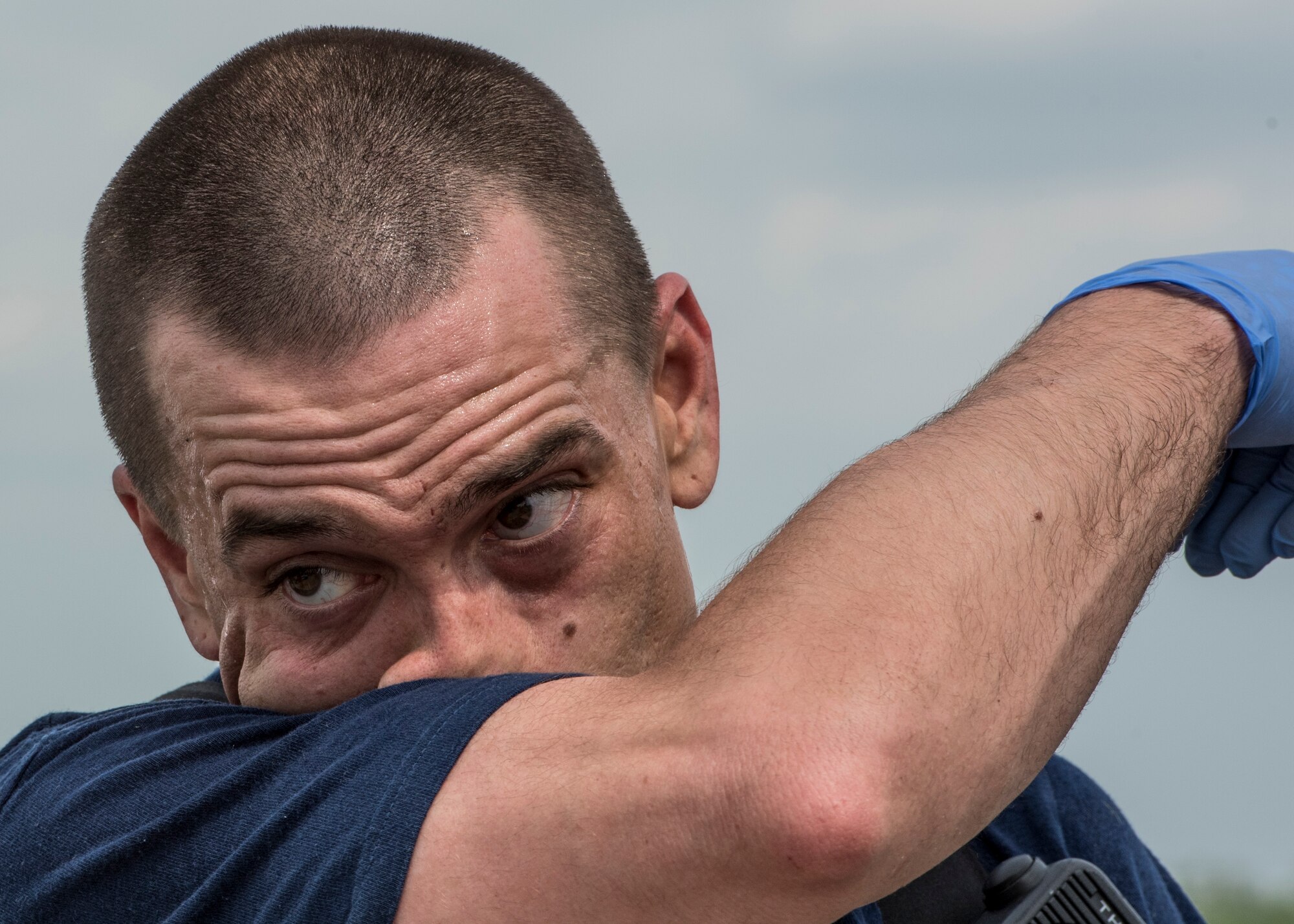 Senior Airman Andrew Brock, 932nd Civil Engineer Squadron firefighter, wipes sweat from his forehead after tending to all of the simulated injured patients during an exercise preparing Scott Air Force Base personnel for air show incident response, Scott Air Force Base, Ill., April 20, 2017.   Brock, a reservist, worked alongside 375th Civil Engineer Squadron firefighters to work on (U.S. Air Force photo by Staff Sgt. Jodi Martinez)