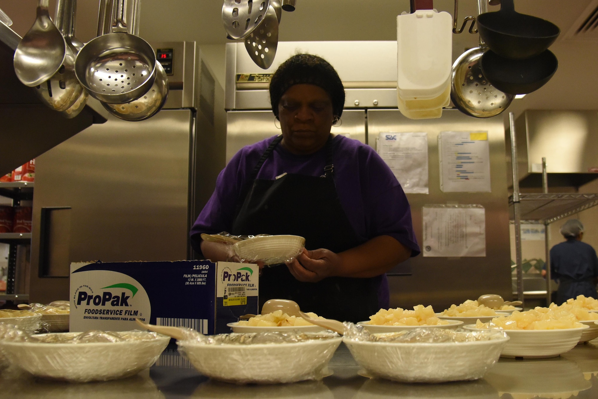 Denise Dinkins, 341st Force Support Squadron food service worker, wraps bowls of sliced pears at the Child Development Center April 24, 2017, at Malmstrom Air Force Base, Mont. Food is prepped and stored up to seven days after opening. (U.S. Air Force photo/Senior Airman Jaeda Tookes)