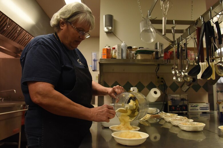 Judith Suden, 341st FSS kitchen supervisor, purées pear slices for babies to eat at the Child Development Center April 24, 2017, at Malmstrom Air Force Base, Mont. Suden incorporates fruits and vegetables to the meals prepared for the children, which is approved by the United States Department of Agriculture, Child and Adult Care Food Program and Air Force guidelines. (U.S. Air Force photo/Senior Airman Jaeda Tookes)