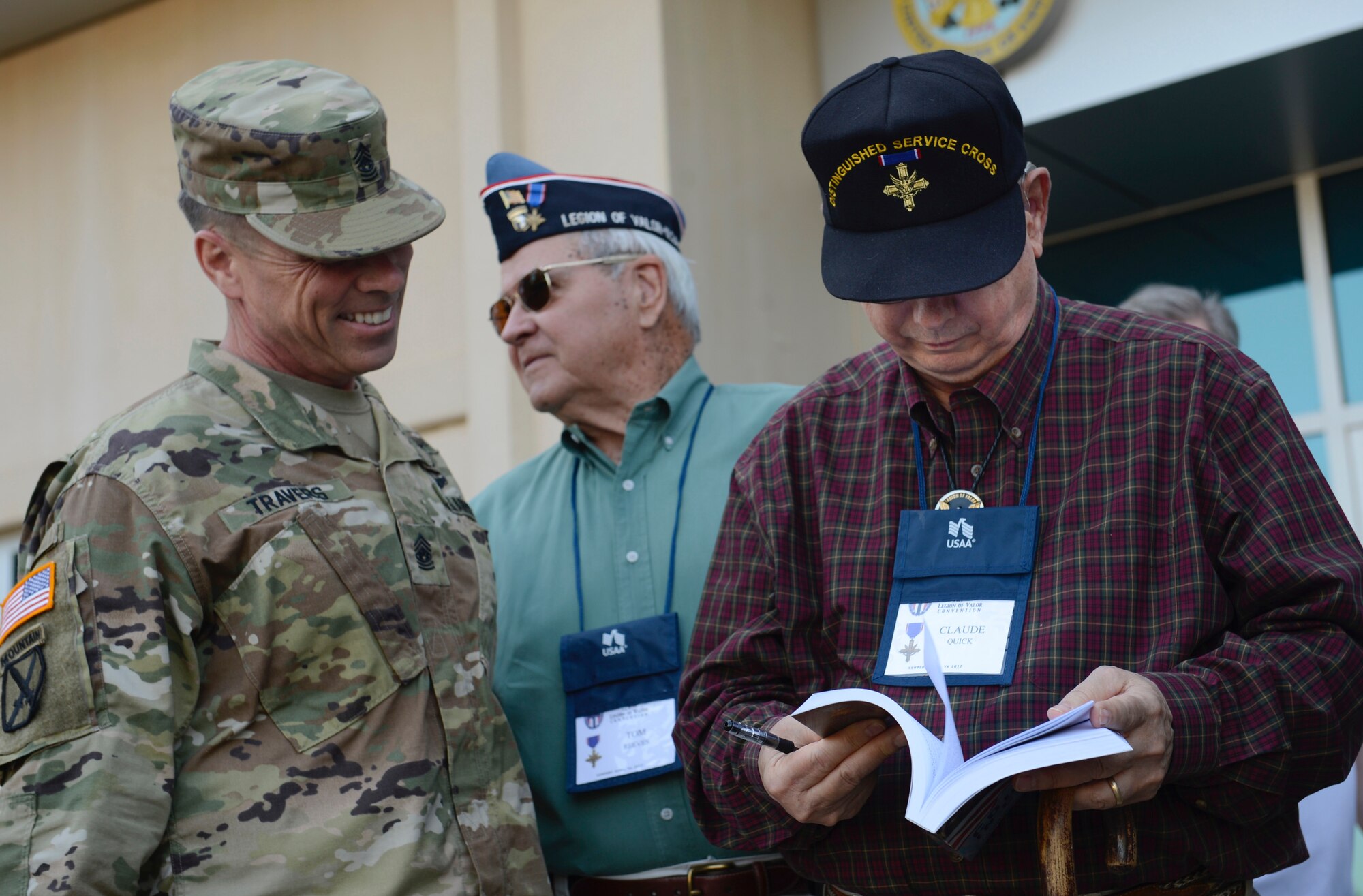 U.S. Army Command Sgt. Maj. Stephen Travers, Army Capabilities Integration Center command sergeant major, asks Retired U.S. Army 1st Sgt. Claude Quick, Legion of Valor member, to sign ‘Courage in Combat: Stories By and About Recipients of the Nation’s Highest Decorations’, a book written by the members of the Legion of Valor during a tour at Joint Base Langley-Eustis, Va., April 21, 2017. Quick was presented the Distinguished Service Cross at the Hall of Honor in Washington, D.C., 25 years after retiring from the Army. (U.S. Air Force photo/Airman 1st Class Kaylee Dubois)